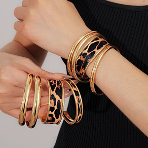 Gros plan de bracelets superposés motif léopard et joncs dorés pour femmes à la mode