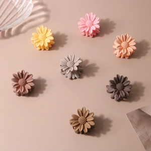 Daisy shaped small hair claws in Morandi colors shown from a top-down perspective