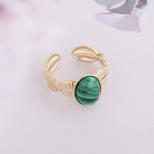 Macro view of gold adjustable ring featuring an oval green malachite stone and feather relief