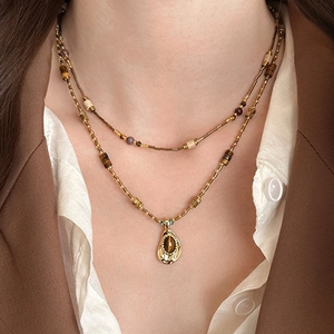 Double-layered gold bead necklace featuring an irregular tiger eye stone pendant