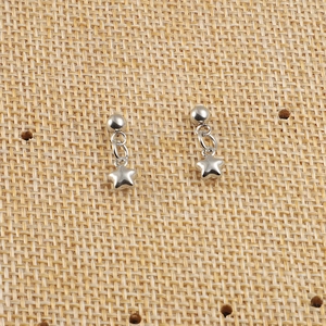 Détail de boucles d'oreilles clous en acier argenté avec pendentifs étoile épurés
