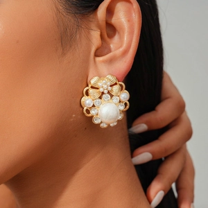 Close-up of vintage flower stud earring with large faux pearl and crystal accents on model