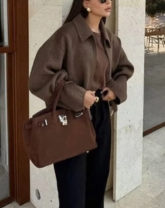 Gros plan d'une veste courte marron à fermeture éclair et col à revers pour femme