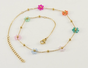 Detailed close-up of gold chain bracelet with vibrant colorful crystal floral charms