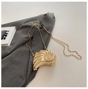 Makro-Detail der goldenen Nautilus-Abendtasche mit luxuriöser metallischer Spiralstruktur