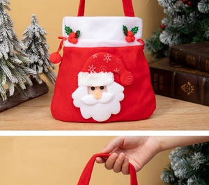 Détail du sac cadeau de Noël en feutre avec poignée rouge et décorations 3D du Père Noël
