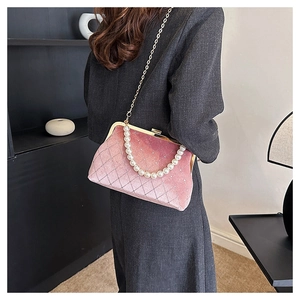 Detailed view of pink velvet shell bag with quilted texture and pearl chain strap