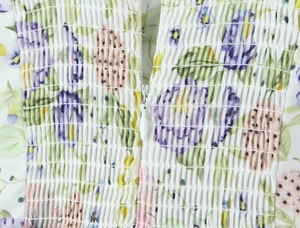 Détail de robe florale montrant le tissu froncé élastique et la fermeture invisible