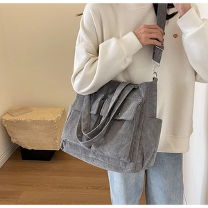 Gray corduroy tote bag detail showing multi-pocket design for school and commuting