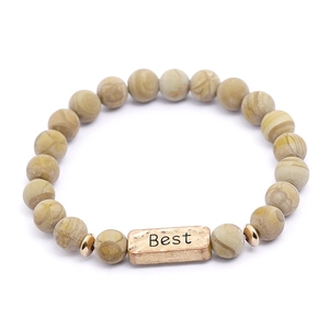 Macro shot van natuurlijke yoga kralenarmband met gegraveerde Best gouden plaat
