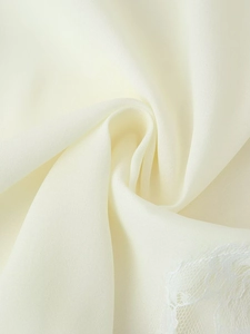 Close-up of cream white chiffon fabric with delicate lace拼接 and elegant drape texture