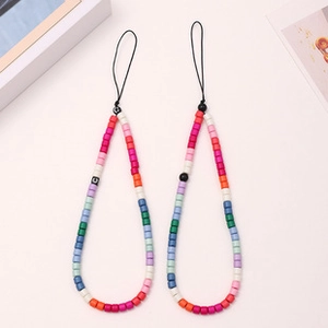 Close-up of two colorful beaded phone charms with red and white cylindrical beads