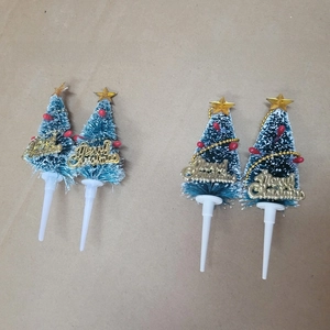 Detail of a frosted mini Christmas tree cake topper with Merry Christmas sign