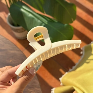 Detail of high-elasticity golden metal spring on large cream matte butterfly hair claw