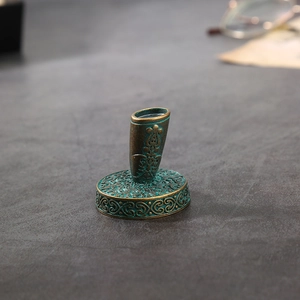 Macro detail of antique bronze pen holder with intricate vintage embossed carvings