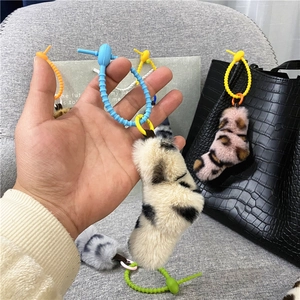 Close-up detail of cute leopard plush keychain with blue twisted tie creative bag charm