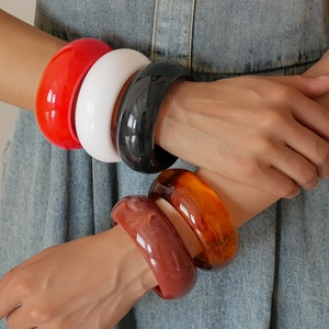 Close-up of colorful resin chunky bangles set in vibrant red, amber, and white colors