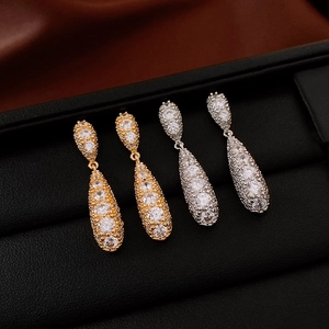 Close-up of gold and silver teardrop tassel earrings with sparkling cubic zirconia inlay