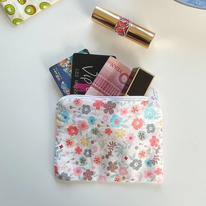 Detail view of floral cotton coin purse showing capacity for cards and lipsticks