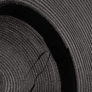 Détail intérieur d'un chapeau en paille noir montrant le bandeau et le tissage fin