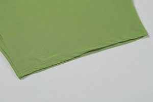 Detailed view of the double-stitched hem on the grass green two-piece resort dress
