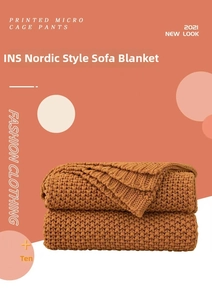 Close-up of thick textured knit throw blanket in burnt orange with Nordic style fringe
