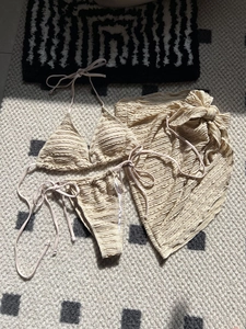 Detailed view of beige ripple textured fabric on three-piece bikini set with sarong
