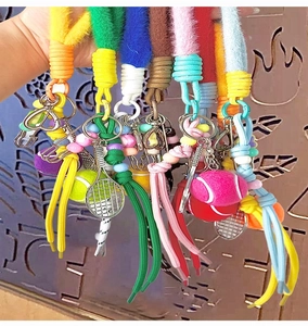Dettaglio di mini racchette da tennis colorate con corde di peluche e perline vivaci