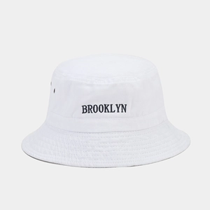 Détail de la broderie Brooklyn et des œillets sur le chapeau bob en coton blanc