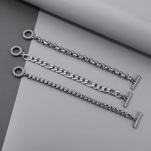 Dettaglio di bracciali in argento con maglie strutturate e chiusure OT con zirconi