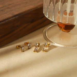 Elegante 18k vergoldete Edelstahl-Ohrstecker mit Zirkonia-Steinen auf strukturiertem Stoff