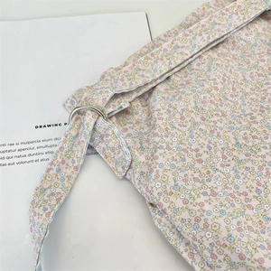Close-up of floral canvas bag showing detailed stitching and silver metal D-ring buckle