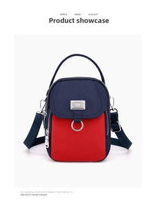 Detail view of navy blue and red nylon crossbody bag with multi-compartment structure