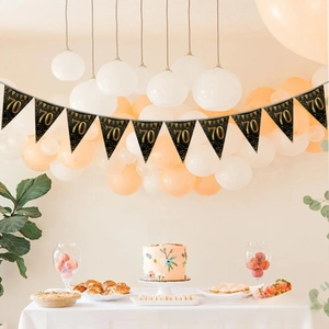 Detail of black and gold 70th birthday triangle bunting flag banner in party setting