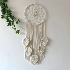 Detail of handcrafted bohemian macramé wall hanging with leaf fringe and cotton weaving