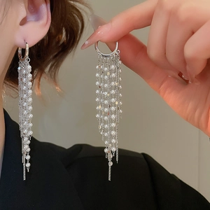 Detail of 18k gold plated long pearl tassel earrings with silver chains and white pearls