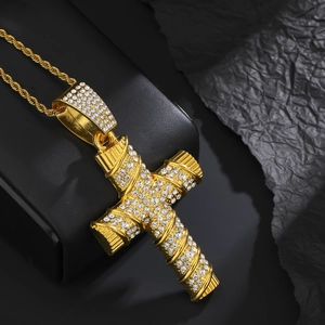 Macro view of gold-plated iced-out cross pendant with sparkling crystals on leather
