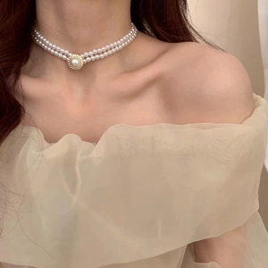 Elegant double-layer pearl necklace with a large pendant on female neck
