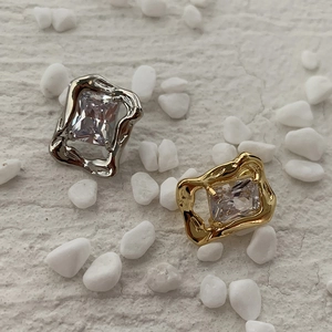 Macro detail of vintage lava style zircon stud earrings in gold and silver finishes