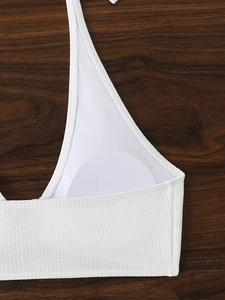 Dettaglio del top bikini bianco a nido d'ape con imbottiture morbide e cuciture rifinite
