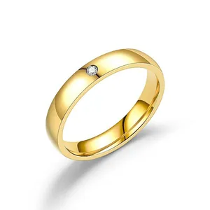 Bague minimaliste en acier titane doré avec diamant rond serti sur fond blanc