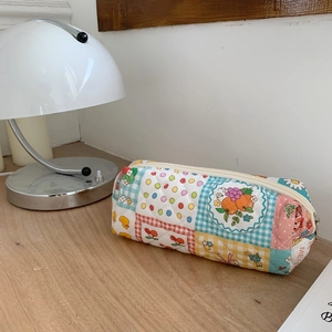 Dettaglio della pochette floreale trapuntata con motivi patchwork e zip superiore