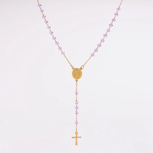 Détail de perles en verre violettes facettées avec médaille dorée et crucifix sur le collier