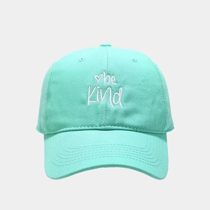 Detail of embroidered 'be Kind' text and heart on mint green cotton baseball cap