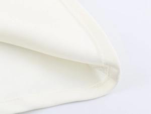 Detailopname van de witte satijnen jurkzoom met professioneel stiksel en gladde textuur