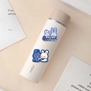 Flat white insulated bunny water bottle with miGo logo on a minimalist desk layout