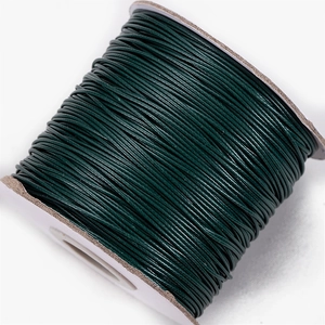 Macro shot of 10m dark green waxed cord roll for DIY jewelry and necklace weaving