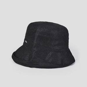 Detail of black woven bucket hat showing breathable mesh texture and silver metal tag