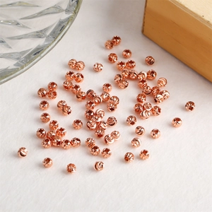 Macro shot of rose gold faceted beads with textured engraving for DIY jewelry making