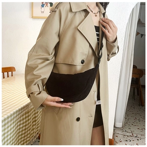 Model wearing black corduroy crescent crossbody bag with a stylish khaki trench coat